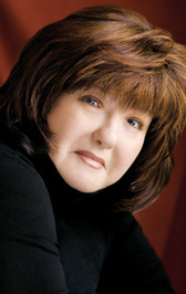 Author Karen Rose headshot photograph: smiling white woman wearing a black top, brown shoulder-length hair