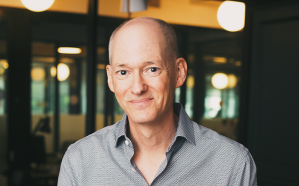 Author Lee Schneider photograph: headshot of older white gentleman, slight smile, wearing a button-down shirt