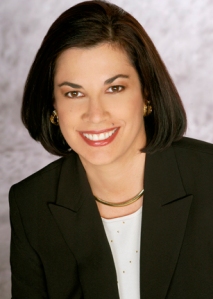 Author Nancy J. Cohen: photograph of a smiling white woman with short dark brown hair, wearing a white top and black jacket.