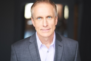 Author Richard Podkowski photograph: a smiling white male wearing a dark gray suit and light-colored button-down dress shirt