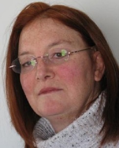 Wendy L. Koenig author photo: headshot of a redhaired white female wearing rimless eyeglasses and a turtle-neck sweater