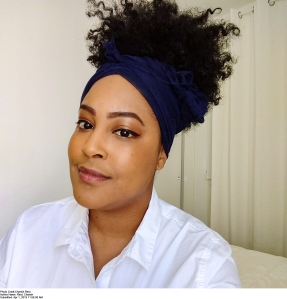 Charish Reid author photo: young Black female wearing a white shirt with a large Afro-puff updo