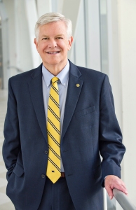 Author Marschall S. Runge M.D. photo: middle-aged white male in a navy blue suit jacket, light blue dress shirt, and yellow and blue striped tie